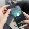NFC Tap-to-Return tracker tapped to smartphone for secure contact sharing.